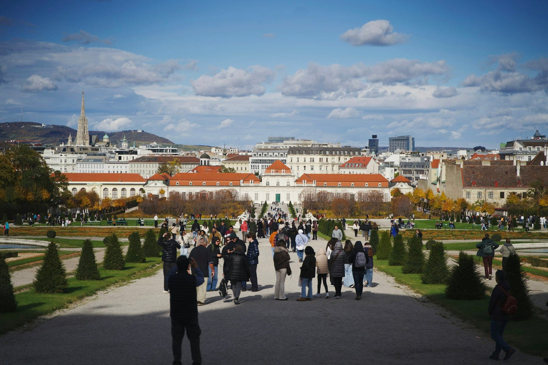 Blick durch die Gartenanlage des Belvedere auf das Untere Belvedere und die Skyline von Wien im Sonnenlicht.